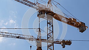 Yellow building cranes in the blue sky. photo